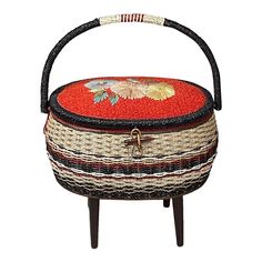 a basket that is sitting on top of a stool with a flower design on it