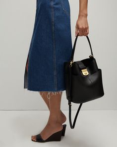 Defined by its sculptural shape, the Crest Lock Bucket bag is an everyday hero. Its distinct yet understated design gives it maximum versatility while it’s relaxed yet sleek look feels of-the-moment. It’s crafted from supple leather and finished with minimalist hardware, including a crest-engraved lock closure. Its luxurious suede interior is finished with a generous flat pocket, while it’s four-compartment exterior allows for further organization. Can be carried as a top handle, crossbody or sh Structured Hobo Bag For Everyday Use, Modern Everyday Bucket Bag With Gold-tone Hardware, Modern Structured Hobo Bag For Everyday Use, Modern Bucket Bag With Gold-tone Hardware For Everyday Use, Modern Bucket Bag For Workwear, Modern Bucket Bag For Work, Modern Bucket Bag With Removable Pouch For Work, Modern Structured Shoulder Bag For Everyday, Structured Shoulder Bag With Gold-tone Hardware For Everyday