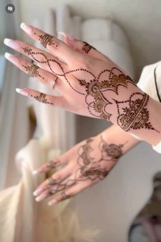 a woman's hand with henna tattoos on it