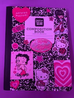 a notebook covered in pink and black stickers on top of a purple tablecloth