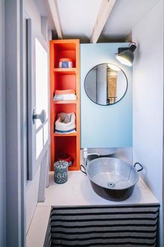 a bathroom with a sink, mirror and shelves