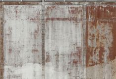 an old rusted metal wall with white paint