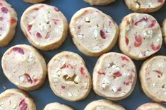 several cookies with different toppings are arranged on a blue surface