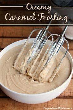 creamy caramel frosting in a white bowl with four whisk attachments