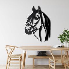 a black and white drawing of a horse on a wall above a dining room table