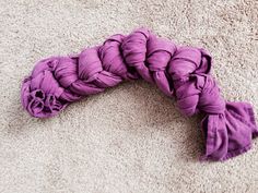 a pile of purple yarn sitting on top of a carpet