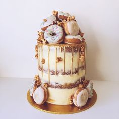 a three tiered cake with donuts and sprinkles on top