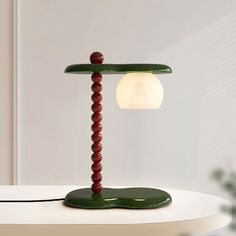 a green table lamp sitting on top of a white table