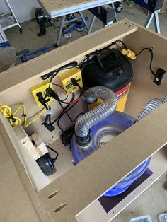 an open box with various tools in it and some wires attached to the inside wall