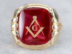 "This large vintage red glass Masonic ring has amazing, yet simply detailed shoulders, rising up from the shank and bending around the corners of the stone. The center is a classic red glass cabochon, inlaid with the gold Masonic symbol, with a nice flat profile. This ring has a substantial feel to it, and makes for a classic Masonic piece! Metal: 14K Yellow Gold Gem: Red Glass Cabochon, Gold Inlaid Masonic Symbol Gem Measures: 16mm x 14mm, Square Cushion Cut Size of Ring: 10 Marks: \"14K\" and Collectible Red Rings With Polished Finish, Heirloom Red Signet Ring With Polished Finish, Classic Red Signet Ring For Formal Occasions, Heirloom Red Ruby Cabochon Ring, Heirloom Red Cabochon Ruby Ring, Classic Red Intaglio Jewelry, Red Oval Intaglio Ring, Collectible Red Ruby Ring With Polished Finish, Red Polished Finish Collectible Jewelry