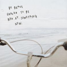 a bicycle parked on the beach next to the ocean with a message written on it