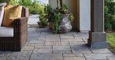 an outdoor patio with wicker furniture and potted plants