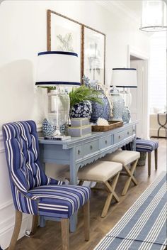 a blue and white dining room with striped chairs