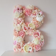 the letter b is decorated with pink and white flowers