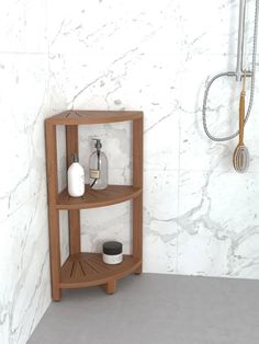 a corner shelf in the corner of a bathroom with soap dispenser and shower head