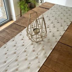 a white table runner with gold stars on it and a candle holder in the middle