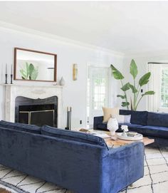 a living room filled with blue couches and a fire place in front of a fireplace