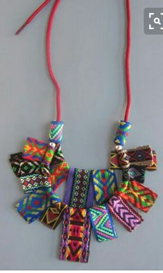 a multicolored necklace is hanging on a red string and it's attached to a cell phone