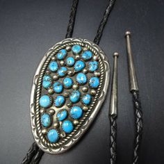 "VINTAGE NAVAJO BOLO TIE DESCRIPTION: Breathtaking specimens of high blue Morenci turquoise set in heavy gauge sterling silver, with hand-stamped border and a field of applied raindrops. This bolo will be a treasured addition to your collection of fine vintage Native American jewelry. MEASUREMENTS: Cord measures 40\" end to end Slide measures 3\" x 1 7/8\" Sterling tips measure 1 3/4\" long WEIGHT: 60.4 grams (including cord) SIGNED: no (Navajo) STERLING: yes, stamped STERLING" Blue Western Style Jewelry With Inlay, Western Style Engraved Blue Jewelry, Antique Blue Jewelry With Patina, Antique Blue Patina Jewelry, Vintage Stamped Blue Jewelry, Blue Vintage Stamped Jewelry, Traditional Blue Concho Jewelry, Turquoise Stone Jewelry, Jewelry Measurements