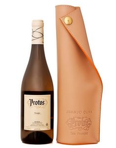 a bottle of wine sitting next to a leather case