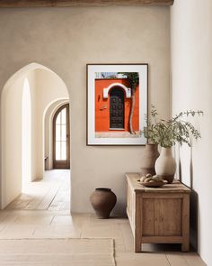 an archway leads to a hallway with potted plants and vases