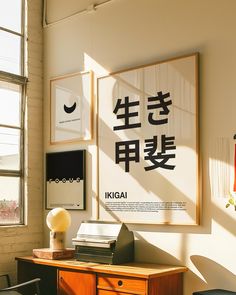 a desk with some books on top of it in front of a large framed poster