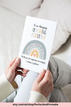 a woman holding up a card that says it's an amazing teaching assistance