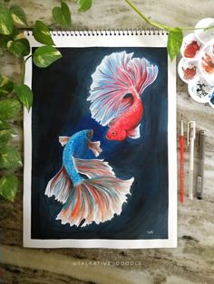 a painting of two fish on a table next to paintbrushes and watercolor paints