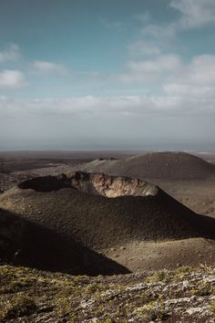 the landscape is covered in green plants and brown hills