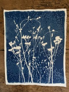 some white flowers on a wooden surface with water droplets all over them and blue sky in the background