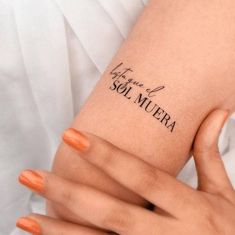 two hands with orange manicures are holding onto each other's wrist tattoos