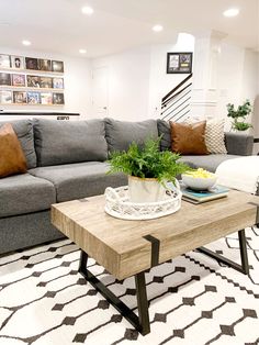 a living room filled with furniture and a plant on top of a wooden coffee table