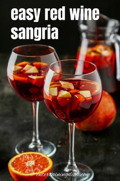 two glasses filled with red wine and sliced oranges