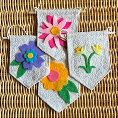 three handmade flower potholders hanging from a wicker basket