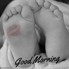 a black and white photo of a baby's feet with pink lipstick on it