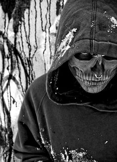 a man in a hooded jacket with a skull on his face and hood over his head