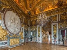 an ornately decorated room with chandeliers and paintings on the walls