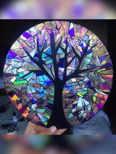 a hand holding up a stained glass tree