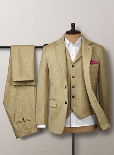 Aim for a lavish take on a casual style with our Highlander Heavy Beige Herringbone Tweed Suit. Most significantly, crafted from a pure wool material expresses a thick, decently rugged and gorgeously soft texture with a distinctive herringbone weave over a brown hue. Additionally, the cloth exudes an enormously cozy vibe, which makes this suit an excellent investment for the winter. Primarily, the precise tailoring suit frames the contour and ensures you look sharp for a charming profile while conducting business or attending a social occasion.  Look Includes  Highlander Heavy Beige Herringbone Tweed Fabric  Two Button Jacket Style  Notch Lapel   Horn Brown  Buttons  Single Vent  Three Cuff Buttons  Two Welted Back Pockets on Trousers   Click 'Customize Now' to modify the look if needed. Tailored Beige Tweed Jacket With Suit Collar, Winter Tweed Three-piece Suit For Work, Fitted Beige Tweed Jacket With Pockets, Classic Tweed Suits With Pockets, Tailored Tweed Three-piece Suit, Wool Three-piece Suit With Welt Pockets For Winter, Fitted Tweed Blazer With Suit Collar, Fitted Beige Tweed Jacket For Business, Luxury Tweed Suit With Notch Lapel