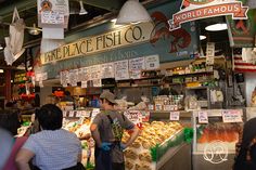 people are standing in line at the fish market and looking for their favorite foods to eat