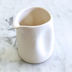 a white vase sitting on top of a marble counter