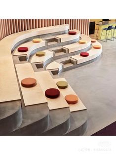 the circular seating area is made out of concrete and has colorful circles on it, along with round cushions