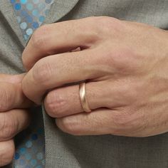 a man wearing a gold wedding band on his left hand and a silver ring on his right hand