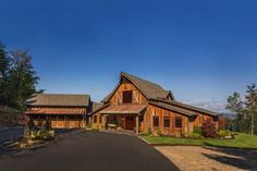 a large wooden house sitting on top of a lush green hillside