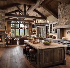 a large kitchen with an island in the middle and lots of wood on the floor