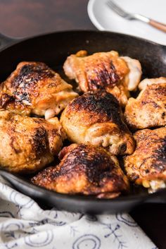 chicken thighs in a skillet ready to be cooked for the dinner guests on the table