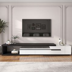 a living room with white furniture and a large flat screen tv mounted on the wall