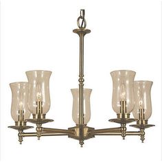 a brass chandelier with five clear glass vases hanging from it's center