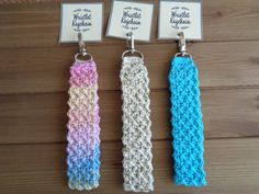 three crocheted key fobs with name tags attached to them