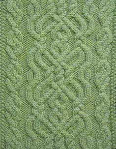 a green knitted blanket with an intricate design